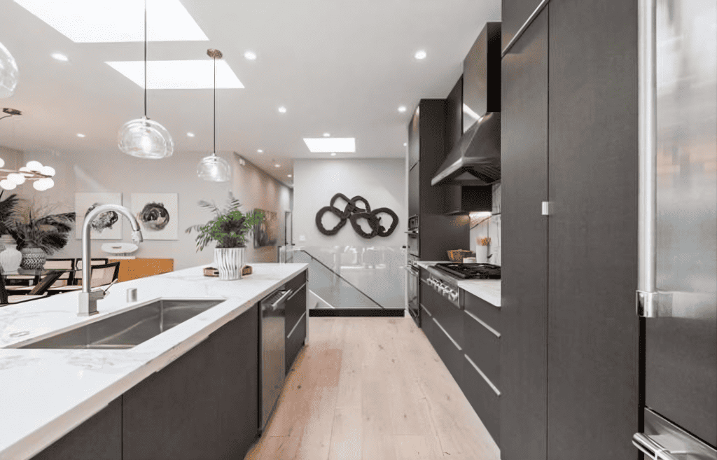 Open-concept kitchen with matte-black cabinetry and skylights in Saratoga whole home renovation by California bay builders & Remodeling